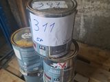 trois pots de peinture sont empilés sur une palette, accompagnés d'une étiquette de prix