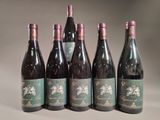 six bottles of wine are lined up on a table