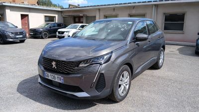La voiture grise est garée sur le parking, à côté d'autres voitures.