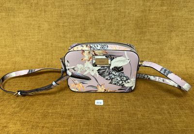 un petit sac à main rose orné d'un motif floral