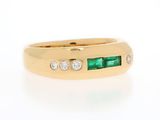 a close up of a gold ring with emeralds and diamonds