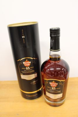 La bouteille de whisky se trouve à côté de la boîte noire sur la table.