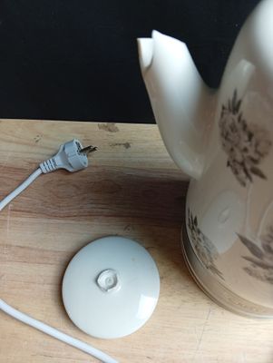a tea pot and a mouse on a wooden table