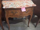 a small table with a drawer on it next to a chair