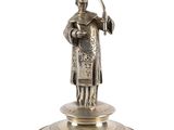 an antique silver figurine of a woman holding an umbrella