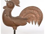 une photo représentant une sculpture métallique en forme de coq posée sur un socle métallique