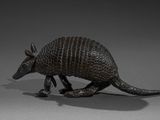a small bronze armadion figurine on a gray surface