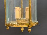 two candles that are sitting inside of a glass lantern
