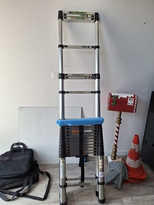 a ladder that is leaning against a wall next to a bag