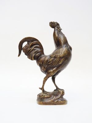 bronze statue of a rooster on a rock on a white background