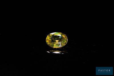 a yellow sapphire stone on a black surface