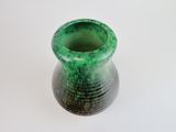 a green vase that is sitting on a white surface