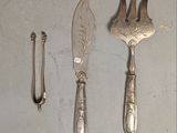 trois cuillères en argent et un couteau posés sur une table