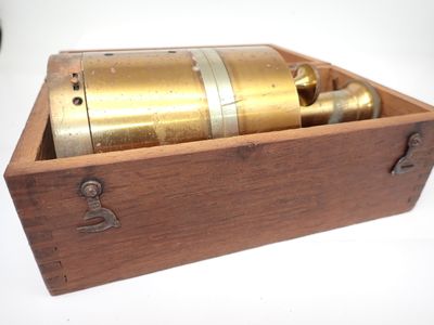 une boîte en bois contenant un objet en laiton