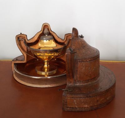 un petit objet métallique posé sur une table à côté d'un bougeoir