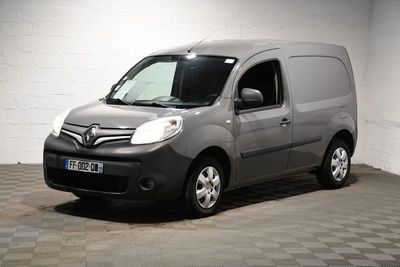 La camionnette grise est garée dans une grande pièce au sol carrelé.