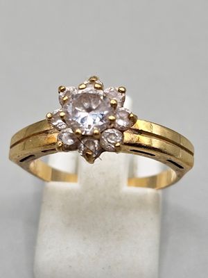 a picture of a gold ring with a white diamond