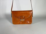 an image of a brown leather purse with a metal handle
