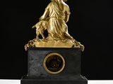 a gold statue of a woman and a dog on a table