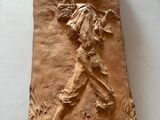 sculpture en argile représentant un homme tenant une batte de baseball, posée sur une surface blanche