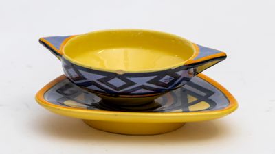 un bol jaune et bleu posé sur une soucoupe