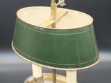 an old fashioned lamp with a green shade on top of it