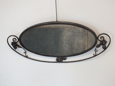 un miroir accroché au mur, avec un cadre en métal