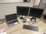 three computer monitors and a keyboard on the desk
