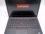 the laptop is open on a white surface with a red lenovo logo on the screen