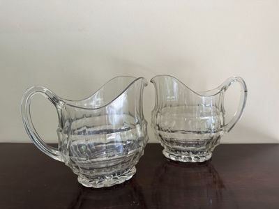 deux pichets en verre transparent posés sur une table en bois