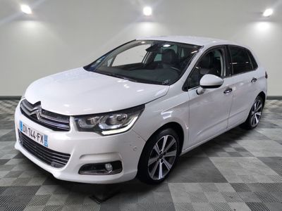 la voiture blanche est garée sur un sol en damier dans le garage