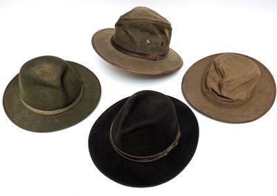 plusieurs chapeaux sont alignés sur une surface blanche