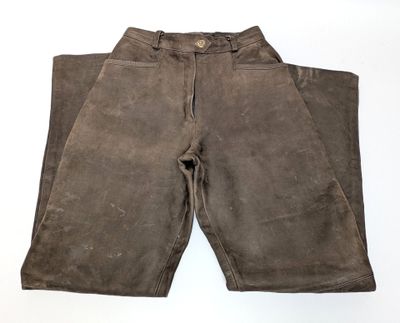 an old pair of brown pants sitting on top of a white surface