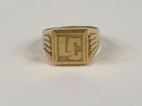 un gros plan d'une bague en or sur laquelle figure la lettre « l »