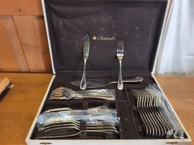 un coffret contenant de l'argenterie, posé sur une table en bois