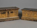 pair of carved wooden boxes with carvings on them on a gray surface