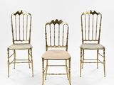 three gold chairs with upholstered backs and upholstered backs
