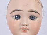 a close up of a doll with blue eyes