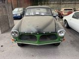 an old car that is parked in a parking lot