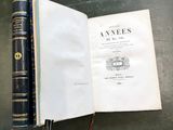 un livre ouvert posé sur une table à côté d'une paire de ciseaux