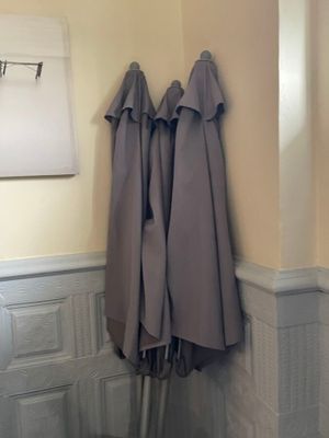 three umbrellas that are hanging on the wall in the bathroom