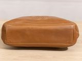 a brown leather toilet bag sitting on top of a wooden table