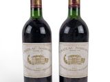 two bottles of wine sitting next to each other on a white surface