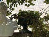 a statue of a man sitting on top of a stone wall