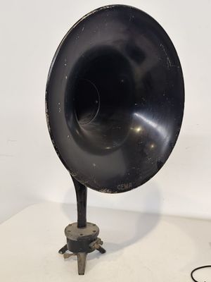 un vieux tourne-disque noir posé sur une table, avec un cordon