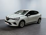 Une voiture blanche est garée dans une pièce au sol noir