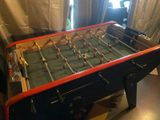 a foosball table in a living room with curtains