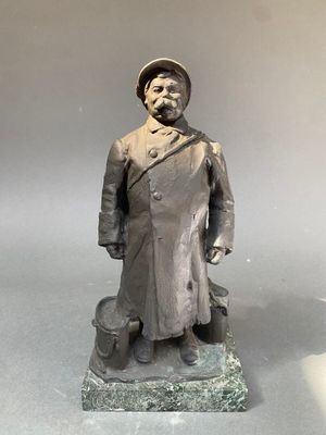 statue d'un homme en manteau et chapeau, debout sur un socle