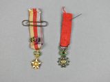 two medals with a star and a ribbon on a gray surface