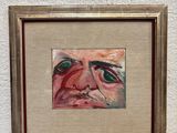 painting of a man ' s face in a gold frame on a white wall